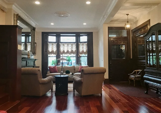 Living room after the remodel, with a bay window, dark wood trim and cherry floors